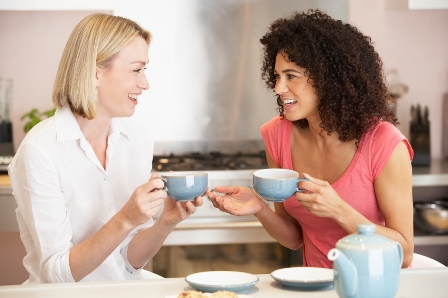 Female Friends Enjoying Tea And Cookies At Home
