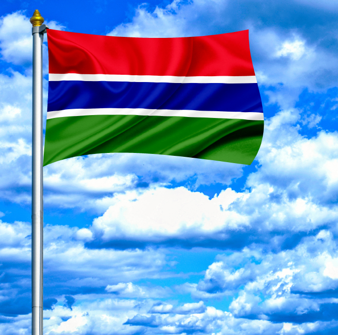 Gambia waving flag against blue sky